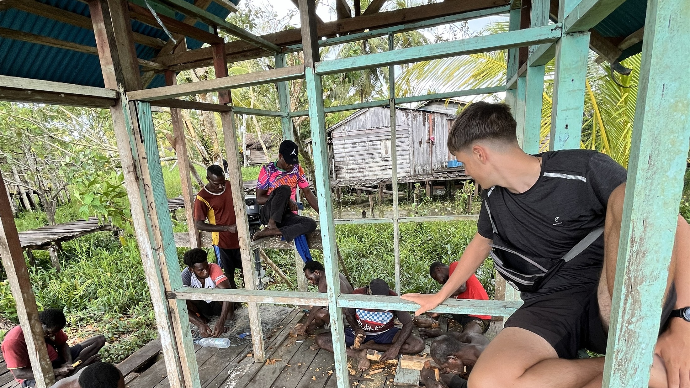 Asmat woodcarvers working together in a village in Papua